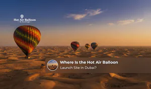 Hot air balloons preparing for takeoff over the Dubai desert at sunrise.